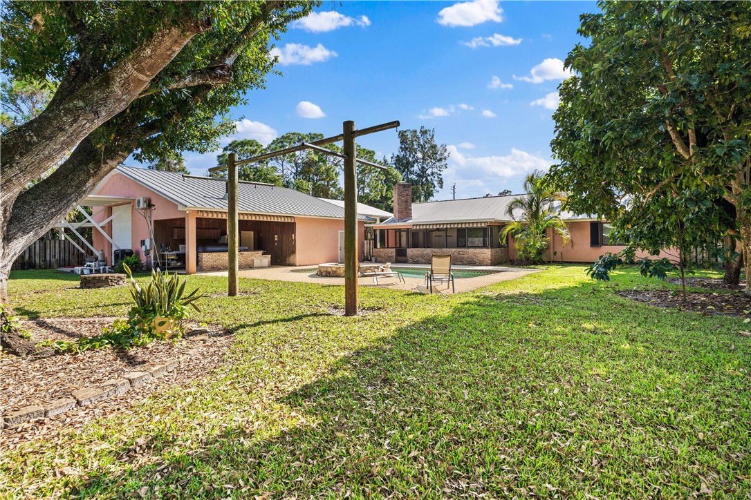 3336 8th Street Vero Beach, FL 32968 - Photo 32 of 36 a view of a house with pool and a yard