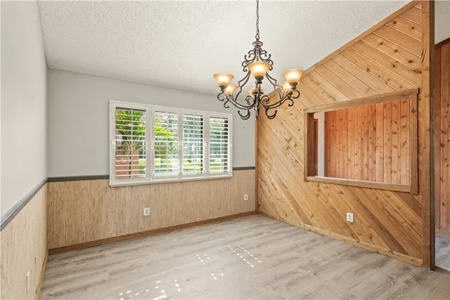 a view of an empty room with wooden floor and a fireplace