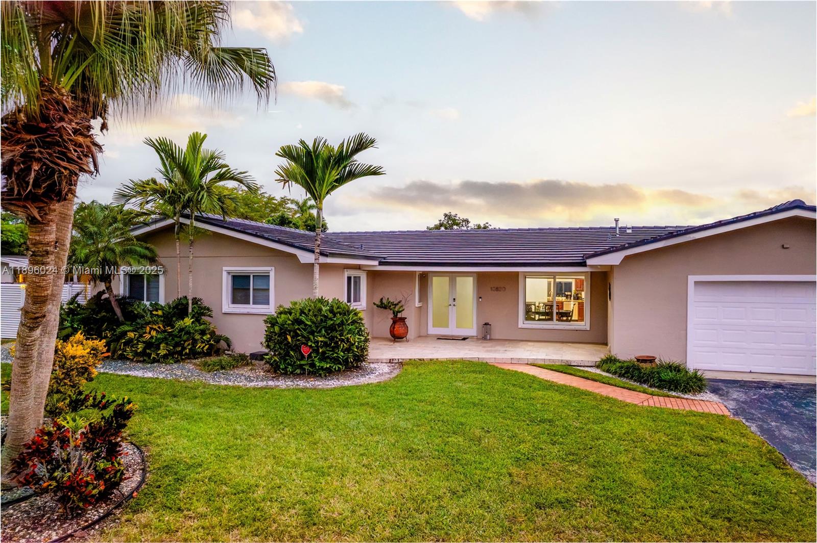 a front view of a house with a garden and yard