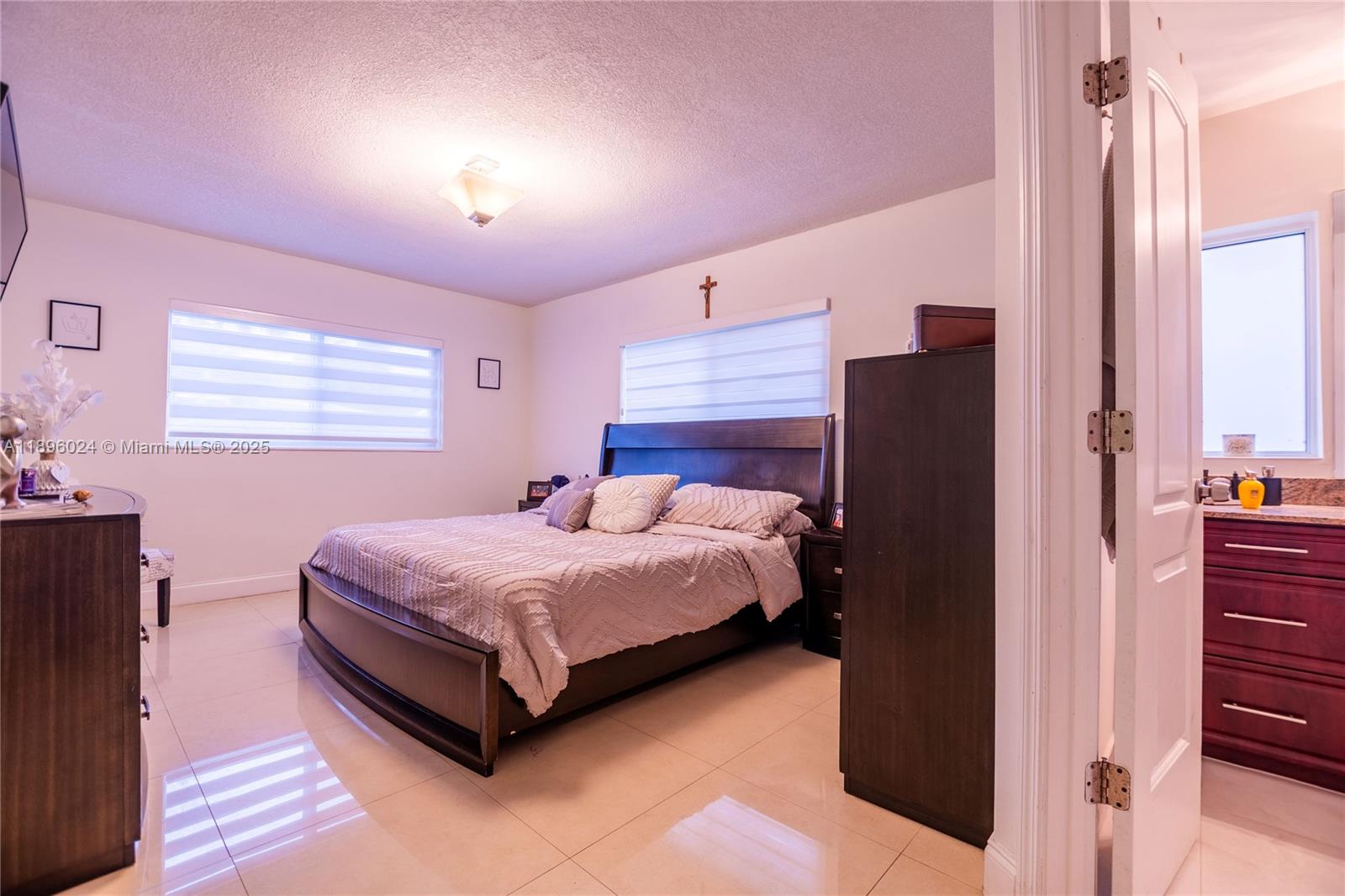 10820 Southwest 125th Street Miami, FL 33176 - Photo 17 of 46 a bedroom with a bed lamp and a dresser