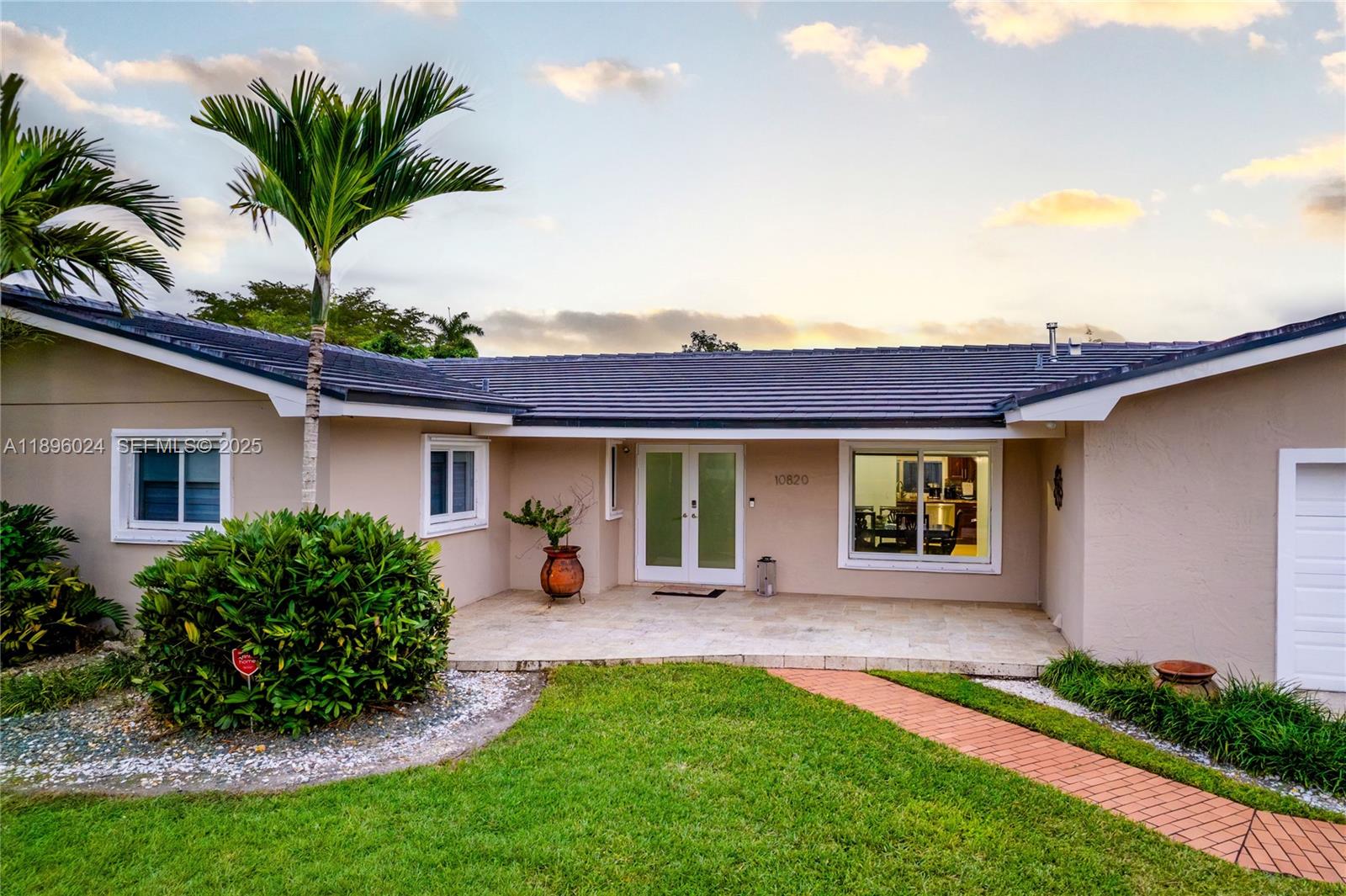 10820 Southwest 125th Street Miami, FL 33176 - Photo 2 of 46 a front view of a house with a garden and yard