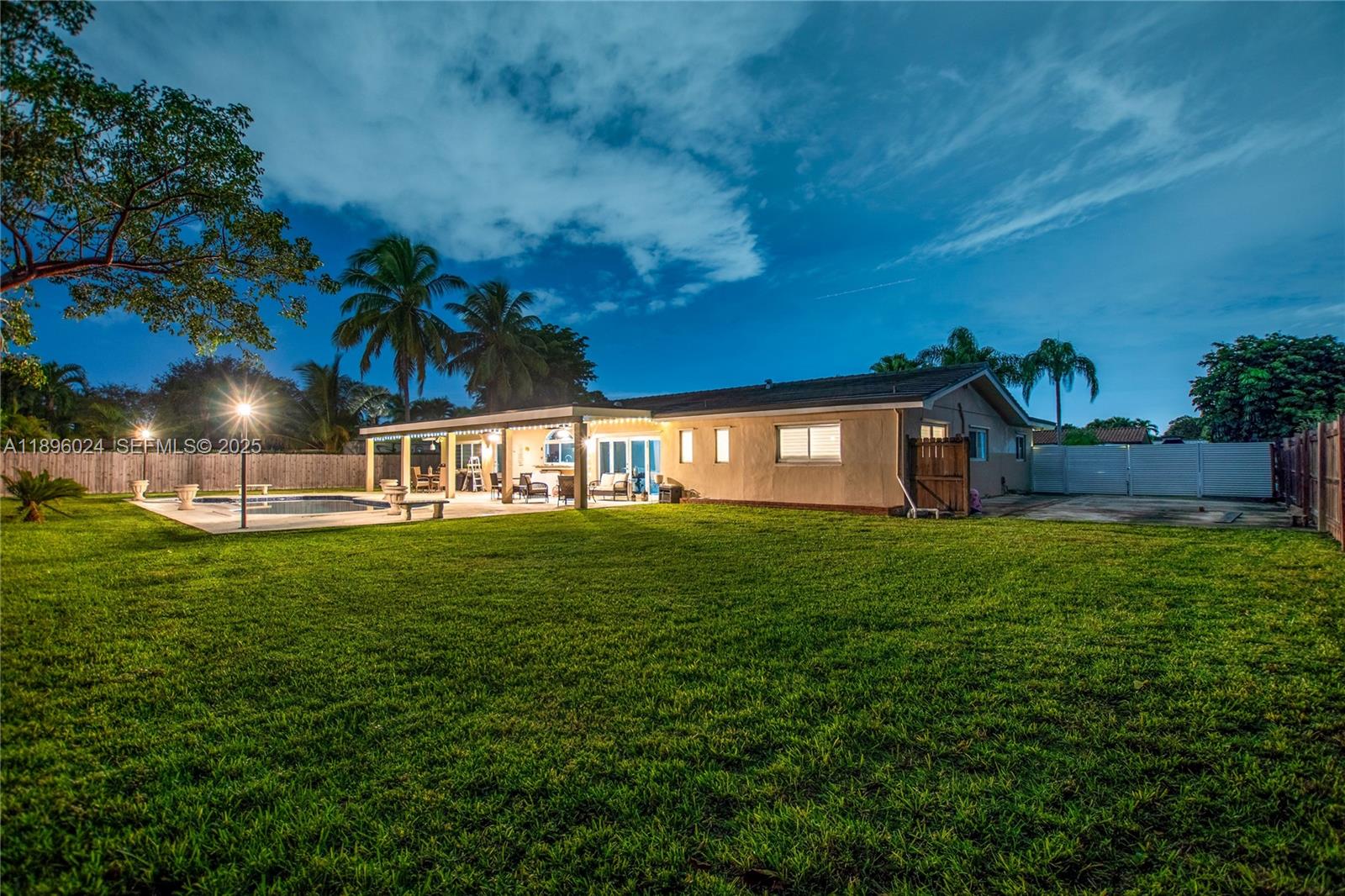 10820 Southwest 125th Street Miami, FL 33176 - Photo 41 of 46 a view of a backyard with table and chairs plants and wooden fence