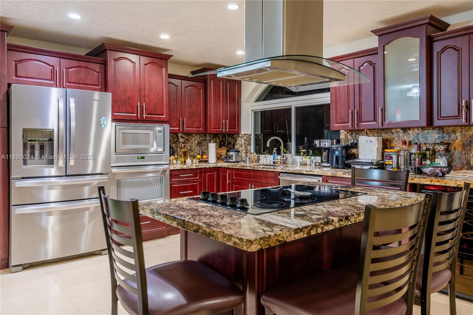 10820 Southwest 125th Street Miami, FL 33176 - Photo 10 of 46 a kitchen with granite countertop a table chairs stove and refrigerator