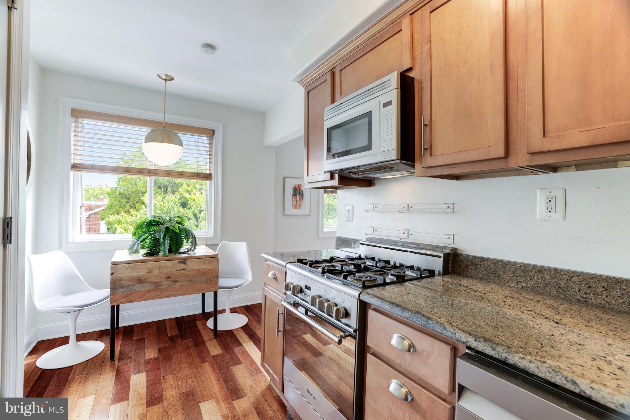 2004 3rd Street Northeast, Unit 201 Washington, DC 20002 - Photo 14 of 35 a kitchen with stainless steel appliances granite countertop a stove a sink and a microwave