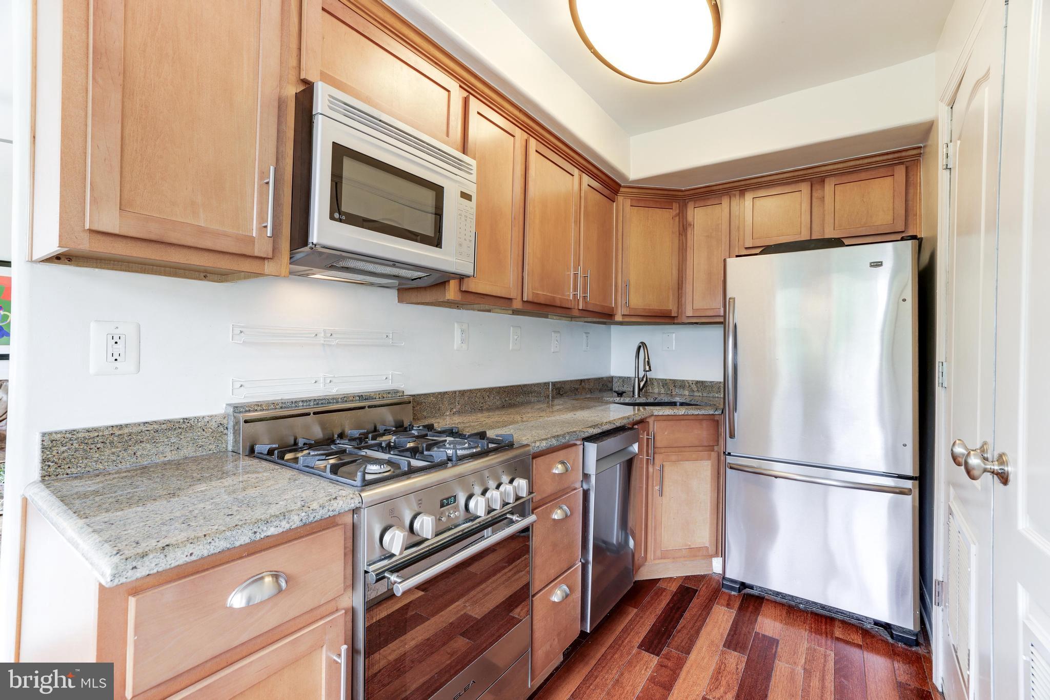 2004 3rd Street Northeast, Unit 201 Washington, DC 20002 - Photo 16 of 35 a kitchen with stainless steel appliances granite countertop a stove a refrigerator and a microwave