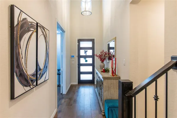 a view of a hallway with wooden floor and staircase