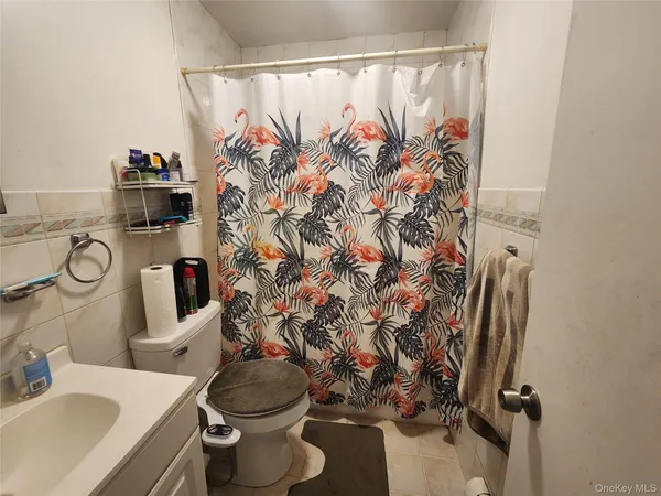 a bathroom with a toilet sink and shower curtain