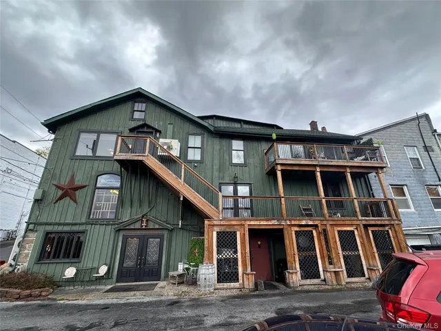 a view of a patio with table and chairs under an umbrella
