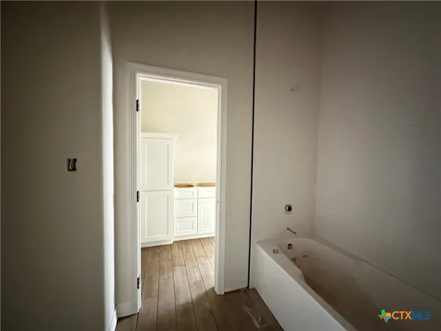 a bathroom with a tub shower and sink