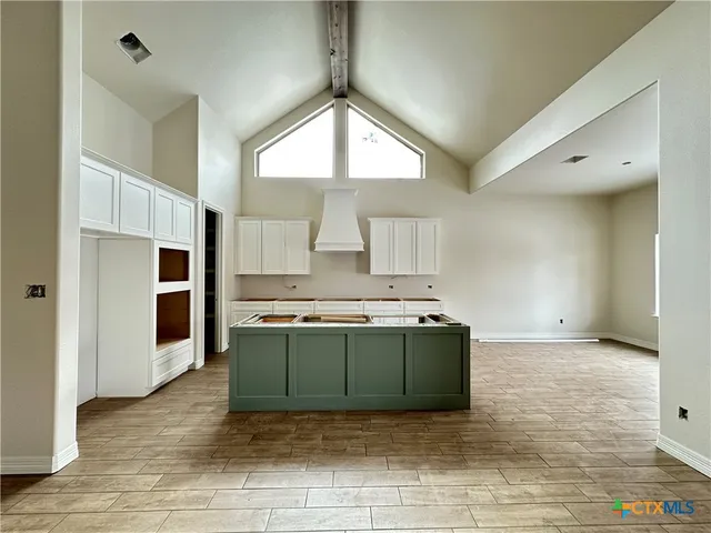 a view of a kitchen with a sink and dishwasher a stove top oven with wooden floor