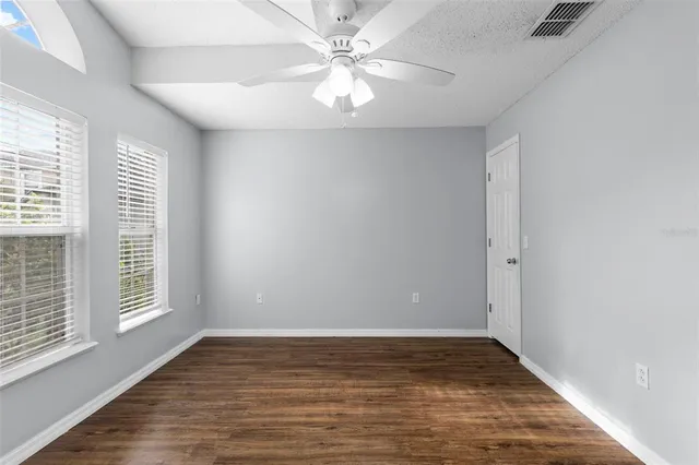 a view of a hallway with wooden floor and a chandelier