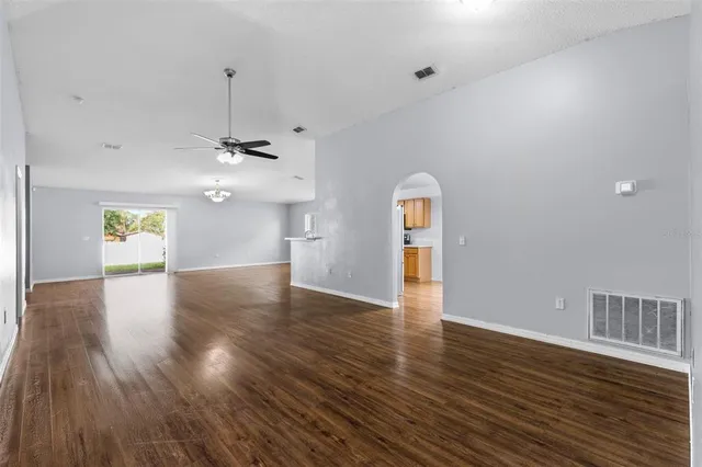 a view of a room with window ceiling fan and hardwood floor