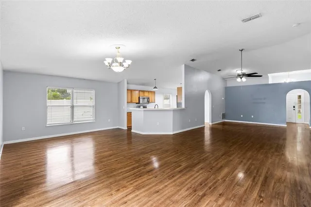 a kitchen with stainless steel appliances granite countertop a refrigerator a stove top oven a sink dishwasher and wooden floor