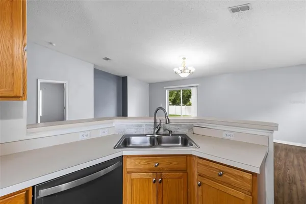 a kitchen with stainless steel appliances granite countertop a refrigerator a oven a sink dishwasher and wooden floor