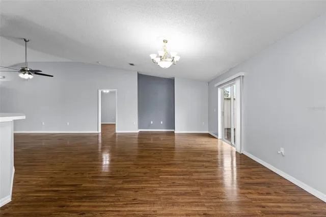 an empty room with fan and windows