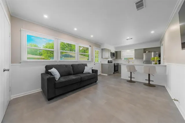 a living room with furniture and floor to ceiling window