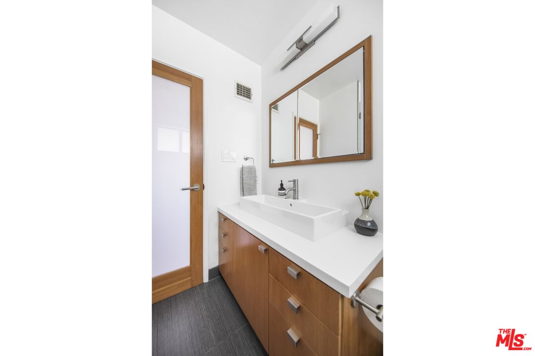 1423 Elevado Street Los Angeles, CA 90026 - Photo 26 of 51 a bathroom with a sink and a mirror