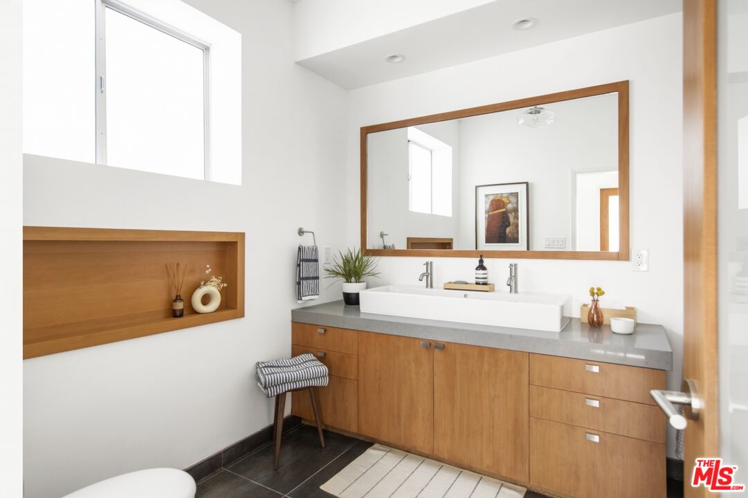 1423 Elevado Street Los Angeles, CA 90026 - Photo 37 of 51 a bathroom with a sink a mirror and a toilet