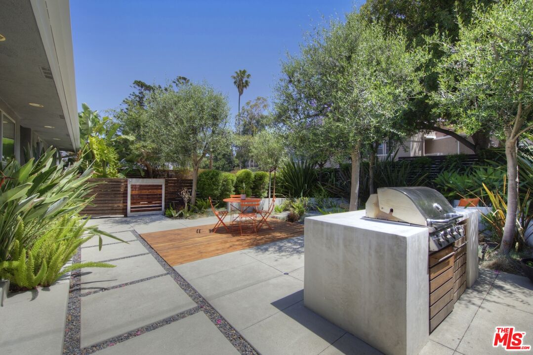 1423 Elevado Street Los Angeles, CA 90026 - Photo 48 of 51 a view of a patio with table and chairs potted plants and a palm tree