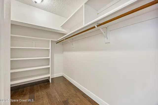 a view of walk in closet with empty racks