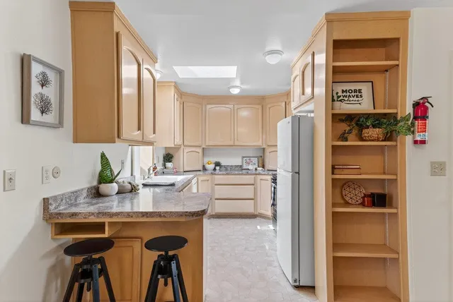 a kitchen with white cabinets and refrigerator