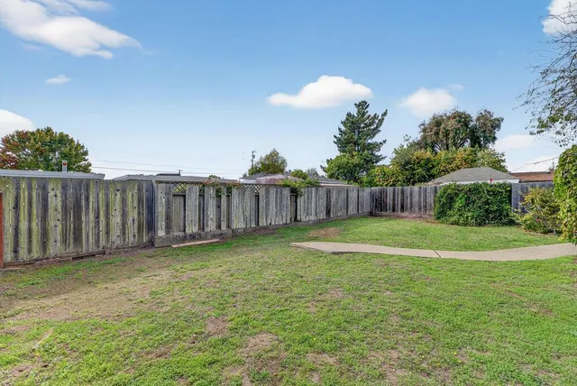 a view of a backyard with wooden fence