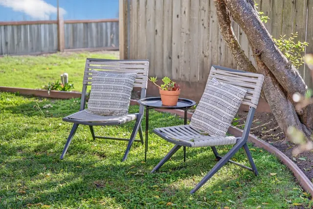 a view of a chairs and table in backyard of the house