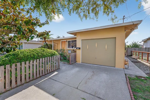 a view of backyard with small cabin and wooden fence