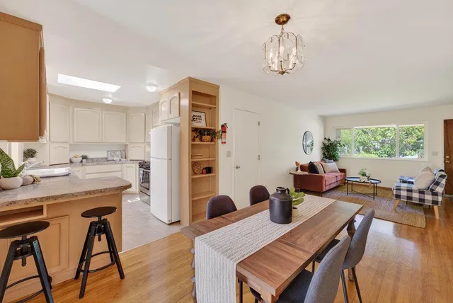a view of a dining room with furniture a chandelier and wooden floor