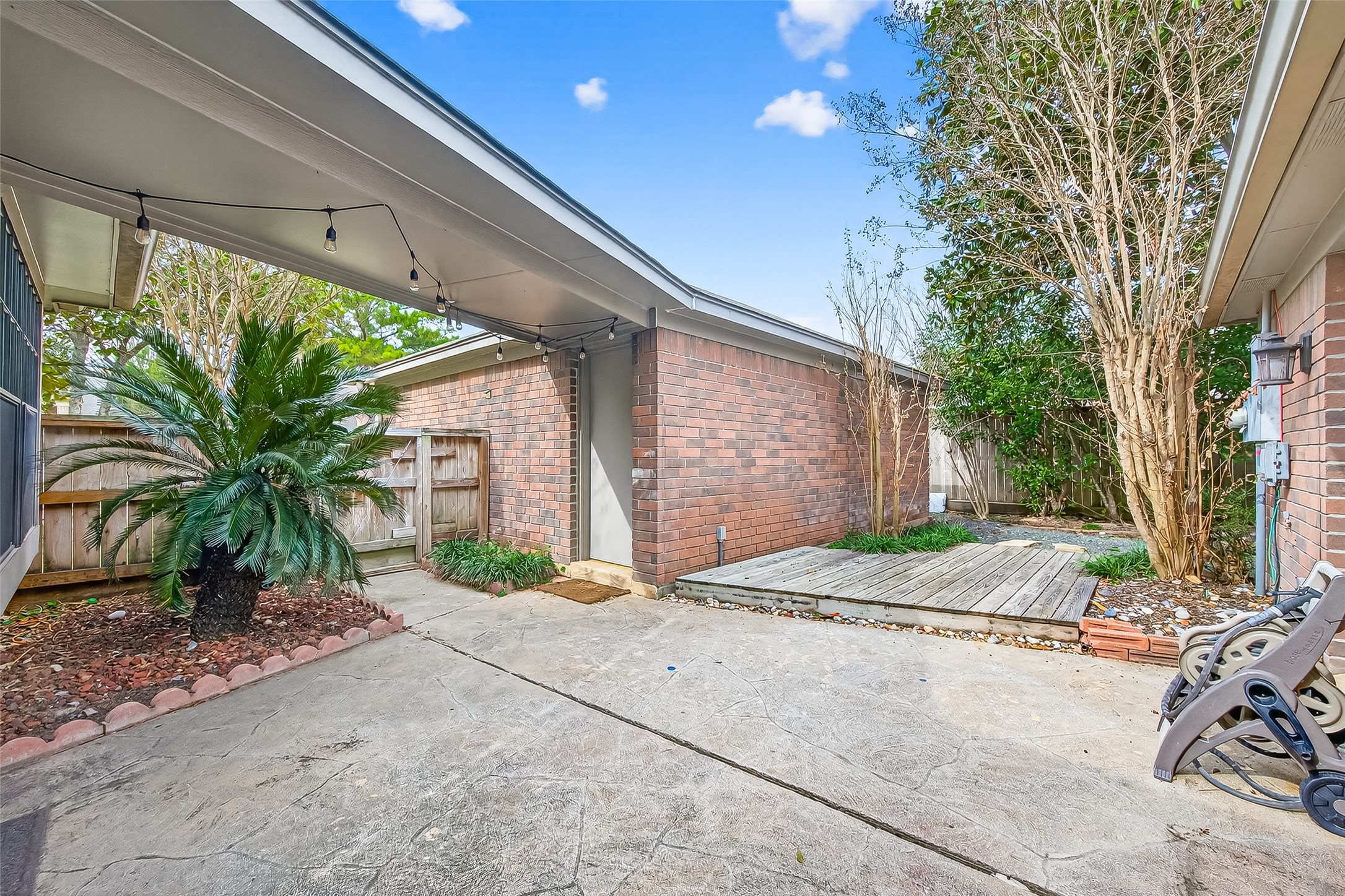 18526 Fawn Run Lane Houston, TX 77084 - Photo 32 of 47 Wide view of the rear courtyard featuring paved walkways, mature landscaping, and brick exterior accents.