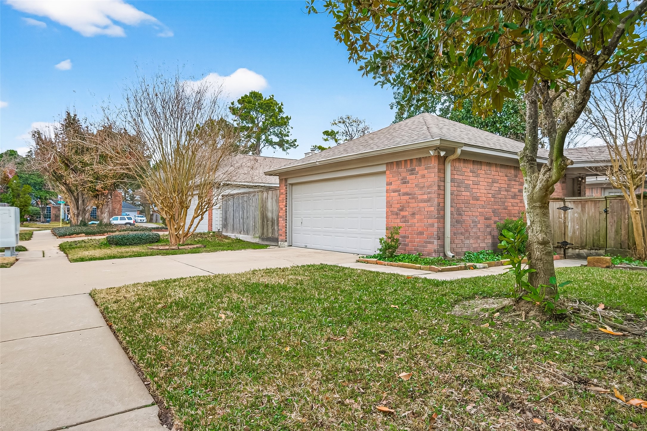 18526 Fawn Run Lane Houston, TX 77084 - Photo 37 of 47 Front yard view with mature trees, green space, and sidewalk access, enhancing the home’s curb appeal.
