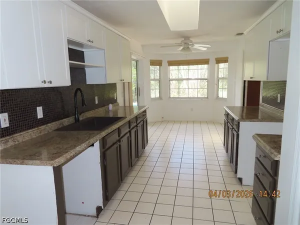 a kitchen with a sink a counter top space cabinets and stainless steel appliances