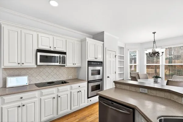 a kitchen with stainless steel appliances granite countertop a white cabinets stove and refrigerator