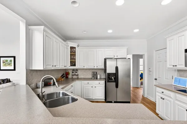 a kitchen with stainless steel appliances a refrigerator sink and wooden cabinets