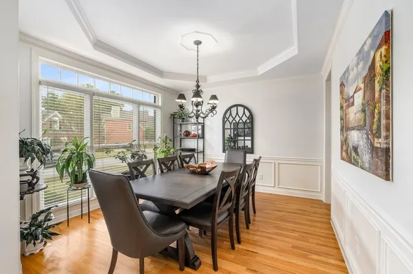 a dining room with furniture a chandelier and wooden floor
