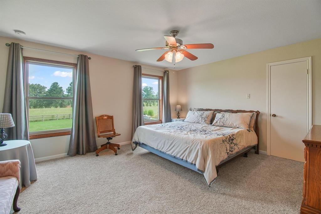 11074 State Highway 64 Overton, TX 75684 - Photo 13 of 40 a bedroom with a bed and large windows