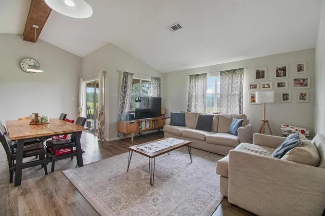 a living room with dining room and wooden floor