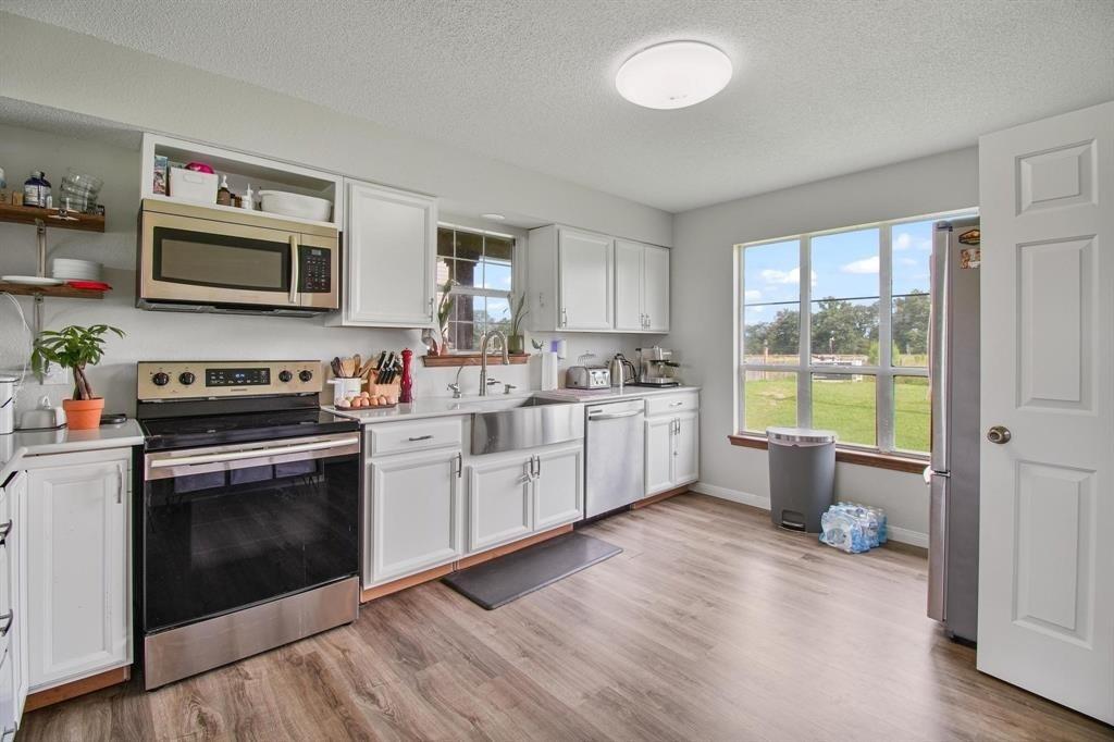 11074 State Highway 64 Overton, TX 75684 - Photo 20 of 40 a kitchen with a stove a sink and a microwave