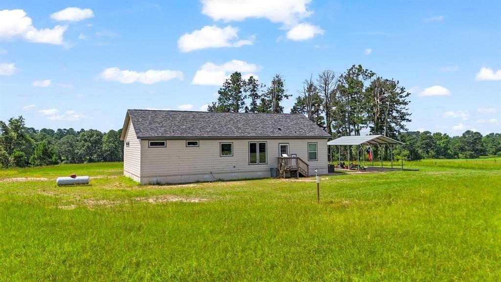 11074 State Highway 64 Overton, TX 75684 - Photo 27 of 40 a view of a house with a big yard and a large tree