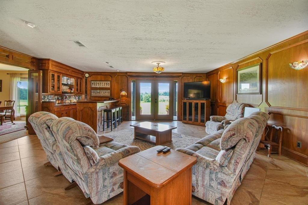 11074 State Highway 64 Overton, TX 75684 - Photo 7 of 40 a living room with furniture a flat screen tv and floor to ceiling window