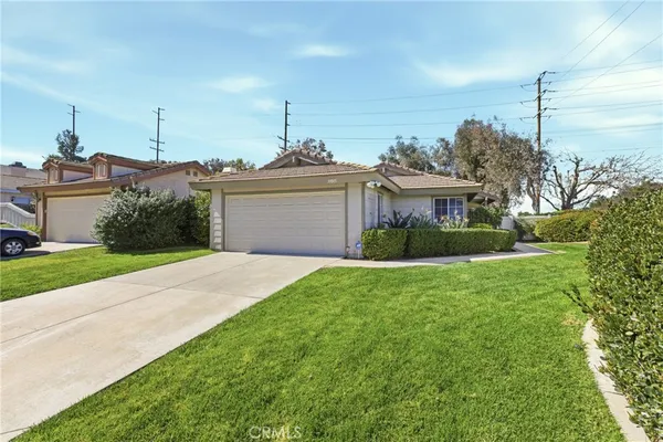 a front view of a house with a garden and yard