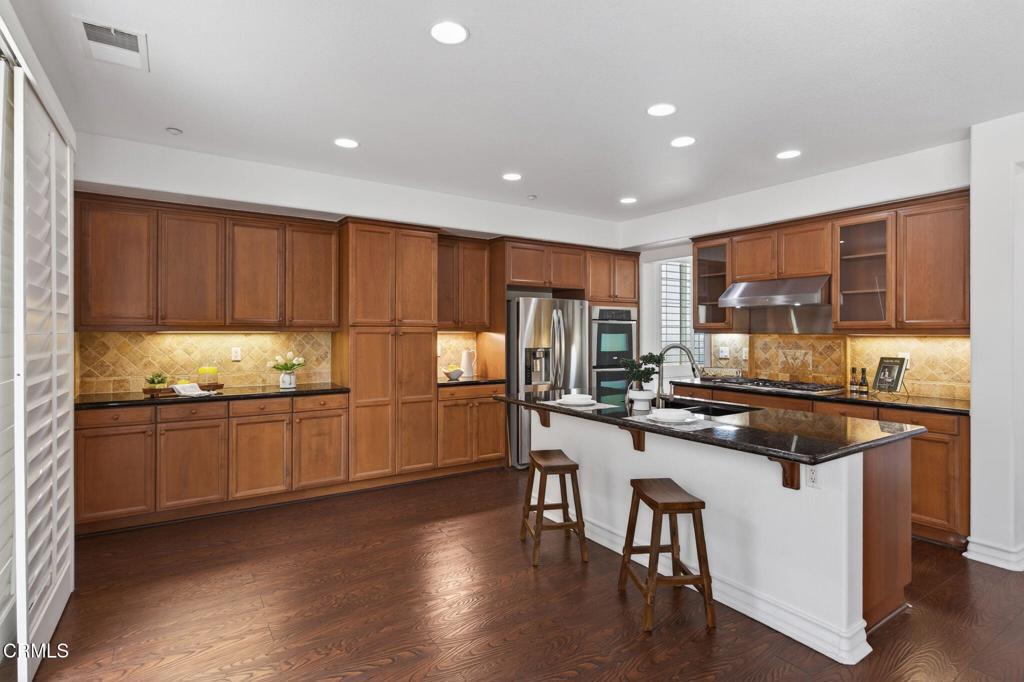 740 Freeport Lane Oxnard, CA 93035 - Photo 13 of 35 a kitchen with stainless steel appliances granite countertop a stove top oven a sink dishwasher and cabinets with wooden floor