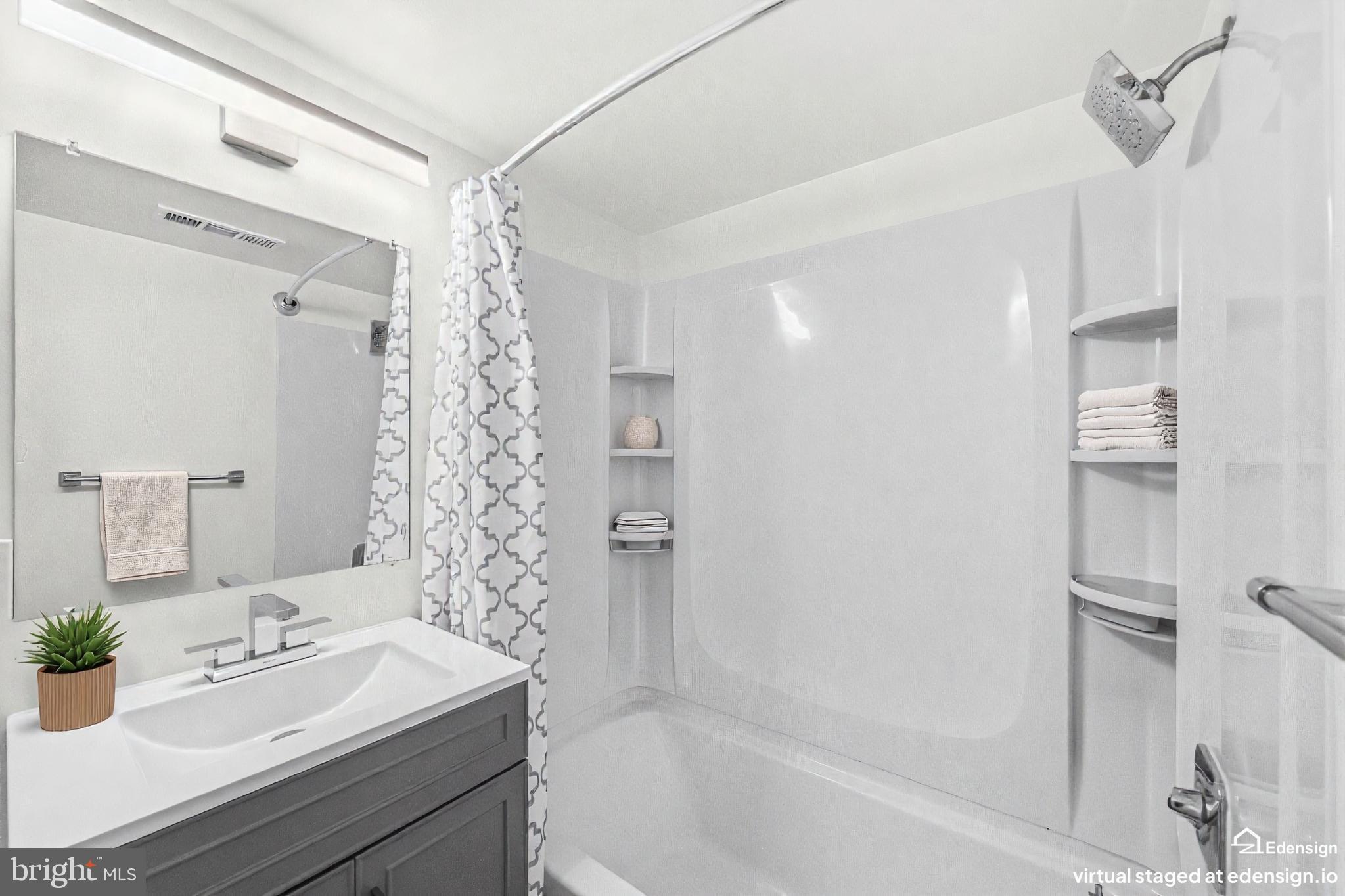 635 Waterloo Road, Unit 222 Warrenton, VA 20186 - Photo 24 of 28 a bathroom with a granite countertop sink a mirror a bathtub and shower