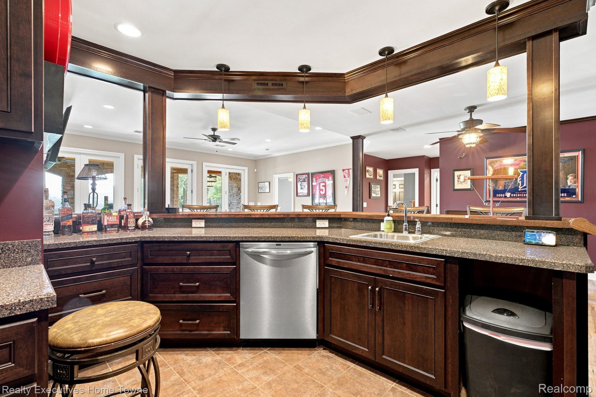 2829 Riverside Drive Port Huron, MI 48060 - Photo 44 of 99 Built-in wet bar with dark wood cabinetry, integrated stainless steel dishwasher, and under-mount sink