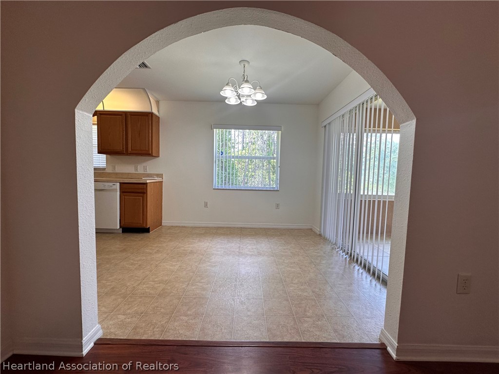 8737 Capilla Street Sebring, FL 33872 - Photo 11 of 43 an empty room with windows and chandelier fan