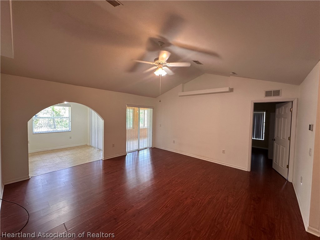 8737 Capilla Street Sebring, FL 33872 - Photo 12 of 43 a view of an empty room with a window and wooden floor