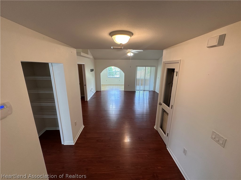 8737 Capilla Street Sebring, FL 33872 - Photo 13 of 43 a view of a hallway with entryway wooden floor and front door