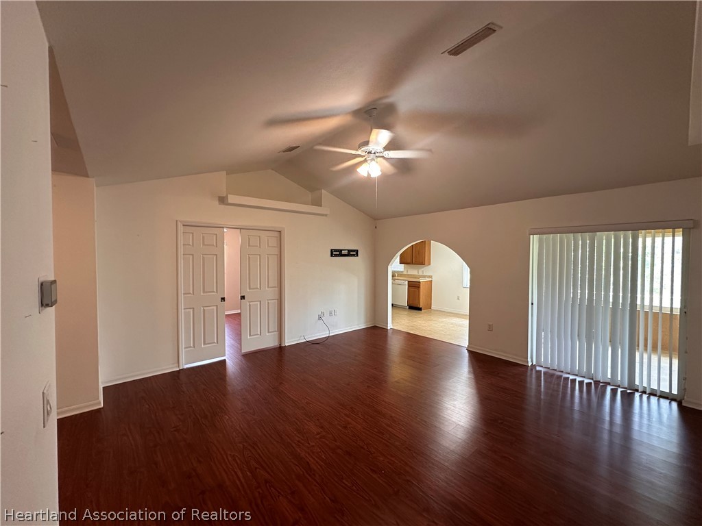 8737 Capilla Street Sebring, FL 33872 - Photo 16 of 43 an empty room with wooden floor chandelier fan and windows