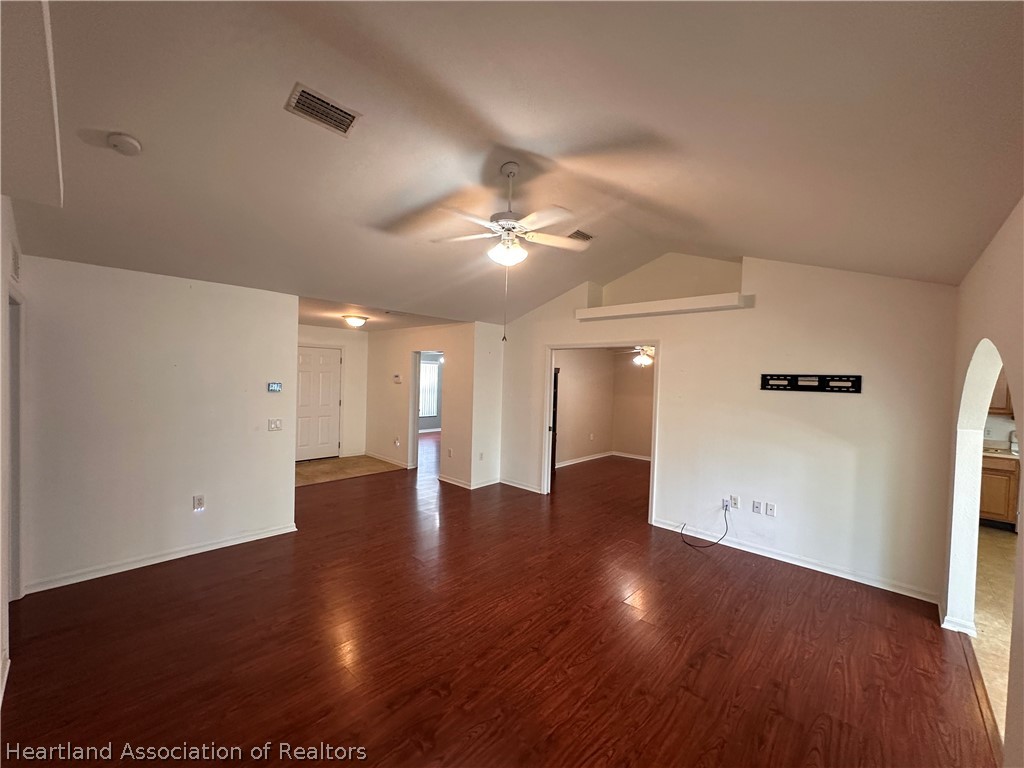 8737 Capilla Street Sebring, FL 33872 - Photo 18 of 43 a view of an empty room with wooden floor and a ceiling fan