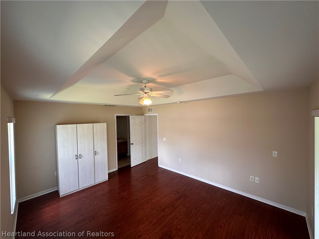 8737 Capilla Street Sebring, FL 33872 - Photo 25 of 43 an empty room with wooden floor and windows